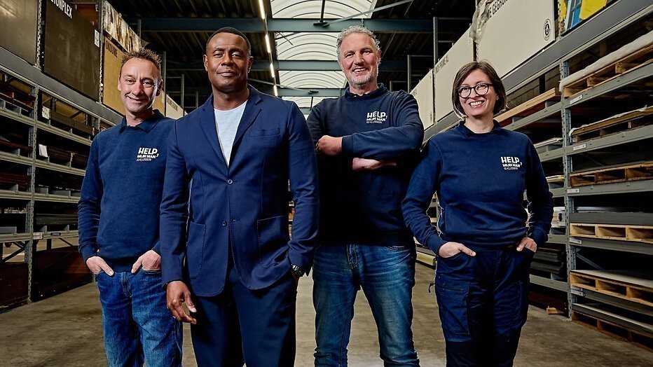 Het team van Help! Mijn Man Is Klusser met presentator John Williams 