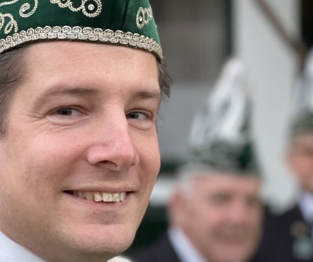 De pastoor host met een biertje mee tijdens het carnaval