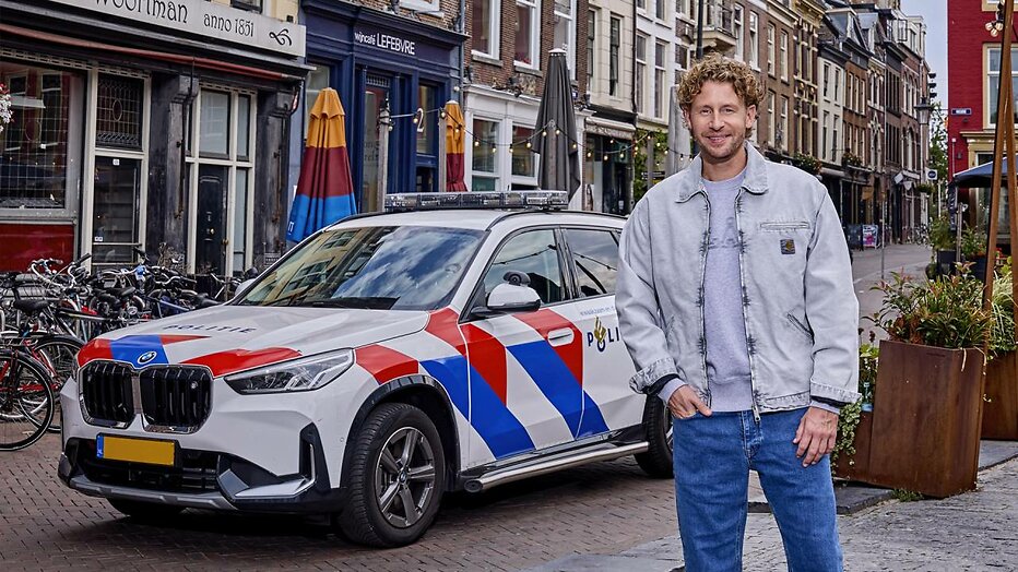 Ewout Genemans bij politiewagen voor Bureau Utrecht.